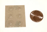 Sheet of 6 clear, round, raised Loc Dots shown next to a penny. Each individual Loc Dot is slightly smaller than the penny.